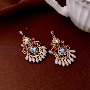 Detailed close-up of vintage bow earrings with colorful rhinestones and beige water drop beads