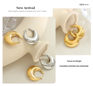 Detail view of gold and silver U-shaped hoop earrings with polished metallic finish
