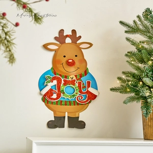 Christmas reindeer wall decor with JOY sign and festive sweater on white wall background