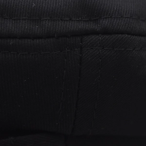 Vue macro détaillée du tissu en sergé noir et des doubles coutures renforcées sur la casquette