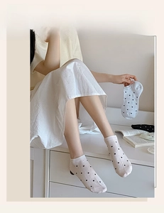 Detailed view of white cotton low-cut liner socks featuring a black polka dot pattern