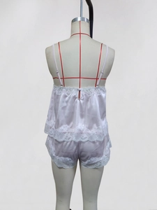 Detaillierte Nahaufnahme des weißen Satin-Pyjama-Sets mit feiner floraler Spitzenborte