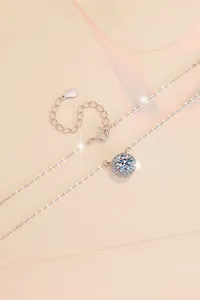 Dettaglio della collana halo in argento S925 con moissanite da 1 carato su sfondo rosa