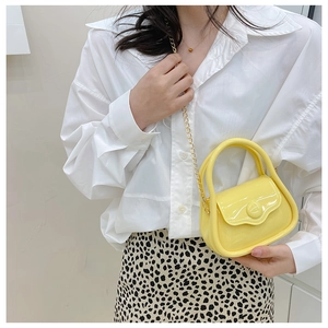 Bright yellow mini jelly bag with gold metal chain shown on model with leopard skirt