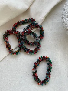 Detailed macro view of colorful faceted crystal beads on woven elastic hair ties