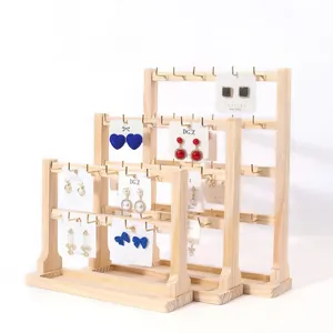 Three-piece wooden jewelry display stands with metal hooks for earrings and necklaces
