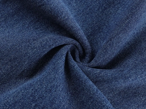 Macro shot of dark blue denim texture with twill weave pattern and washed finish