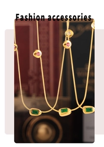 Dettaglio della collana vintage dorata con pietre verdi, rosa e piccoli diamanti lucidi