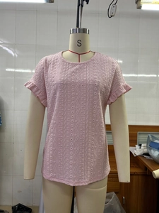 Detailed texture of pink hollow-out knit top with ruffle sleeves on a mannequin