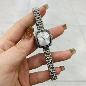 Macro shot of elegant silver ladies' watch featuring a rectangular case and metal strap