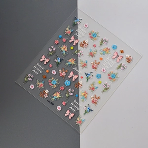Detailed view of 3D embossed floral nail art stickers with bows and colorful bouquets