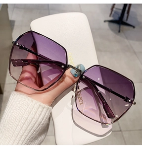 Detail view of purple gradient hexagonal frameless sunglasses with gold metal temples