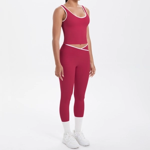 Detail of high-waisted yoga set in burgundy with white contrast piping and cross waist design