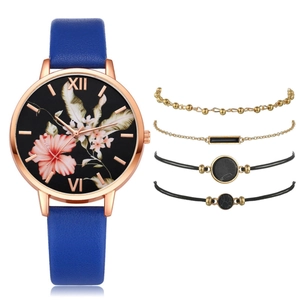 Close-up of women's quartz watch with blue leather strap and matching floral bracelet set