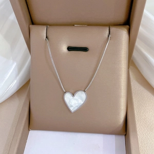 Detail of silver heart-shaped mother of pearl necklace on a delicate snake chain