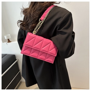 Detail of rose red quilted crossbody bag with gold chain strap and PU leather texture