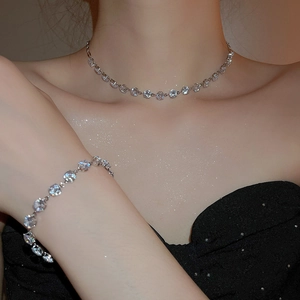 Close-up of sparkling zircon round pendant necklace and bracelet set on a model