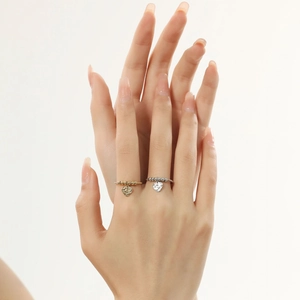 Detailed view of beaded gold and silver heart rings on a model's hand showing texture
