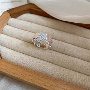 Vue macro de la bague ajustable en émail floral avec pétales colorés et zircon