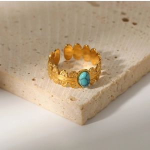Detail of 18K gold-plated ring with oval turquoise inlay and wavy cutout design
