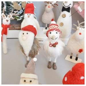 Close-up of handmade wool felt Christmas figurines including Santa, snowman and reindeer