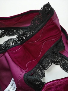 Gros plan sur le tissu en velours bordeaux avec dentelle noire et étiquette d'entretien