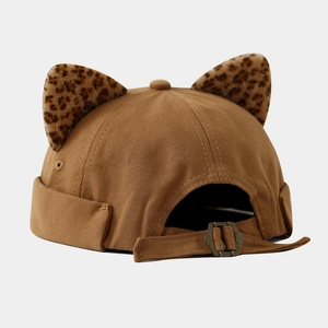 Close-up of a brown docker hat with leopard print cat ears and adjustable metal buckle