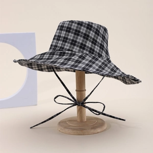 Classic black and white checkered sun hat with wide brim and decorative bow tie detail