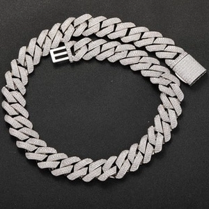 Macro view of iced-out silver Cuban link chain featuring pave-set moissanite stones