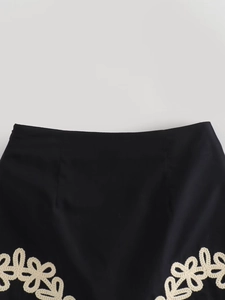 Détail de la broderie crochet florale sur le bord d'une jupe noire chic