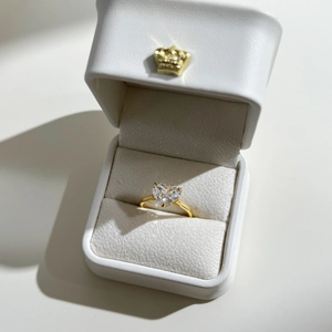 Macro view of heart-cut zircon ring in a luxury white crown gift box display