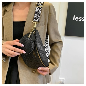 Detail of black woven belt bag featuring a geometric strap and small coin pouch