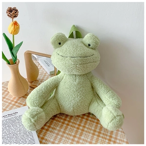 Detailed close-up of a plush green frog backpack on a cozy picnic setup with tulips