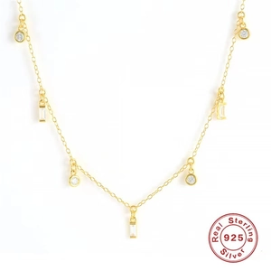 Detail of S925 sterling silver golden necklace with geometric crystal pendants