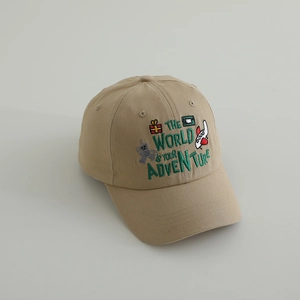 Close-up of colorful embroidery featuring adventure text and cartoon icons on beige cap