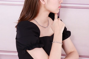 Detail of silver chain necklace and bracelet set on model with minimalist design
