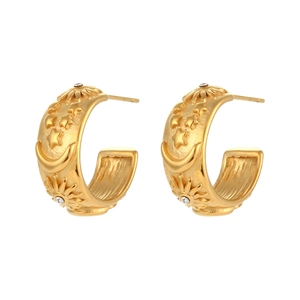 Detail of 18K gold plated C-shaped hoop earrings with embossed sun moon and star motifs