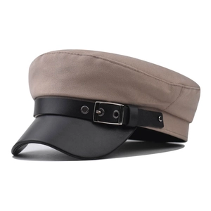 Khaki krantenjongenspet met zwarte lederen klep en metalen gesp in klassieke Britse stijl