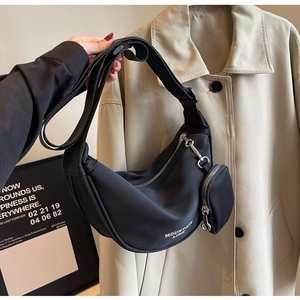 Dettaglio della borsa a tracolla a mezzaluna in nylon nero con portamonete e tracolla regolabile