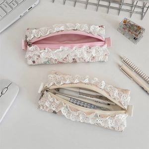 Detailed close-up of floral lace pencil case with metal zipper and printed cotton fabric