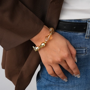 Detail of amber acrylic beads and gold geometric metal beads on a beaded bracelet
