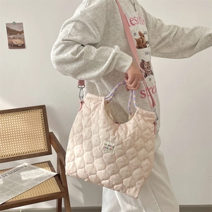 Sac bandoulière en coton matelassé rose tendre avec bandoulière réglable en situation