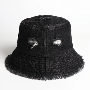 Close-up of distressed black denim bucket hat with ripped details and frayed brim edges