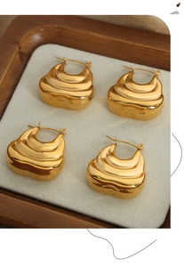 Detailed view of layered golden hoop earrings with high-polish croissant texture