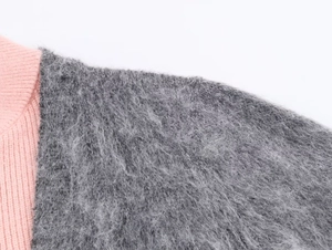 Detail of pink ribbed knit spliced with soft grey mohair textured fabric on the sleeve