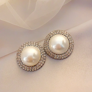 Vue macro de boucles d'oreilles perles avec zircons sertis et bordures dorées
