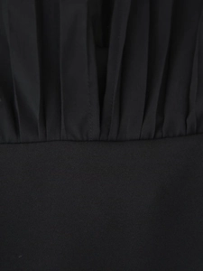 Close-up of black chiffon dress detailing with fine pleats and waist seam texture