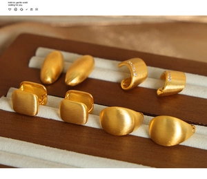 Macro shot of assorted matte gold geometric earrings including square and oval studs