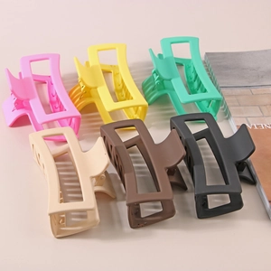 Close-up of matte rectangular hair claws in pink yellow green beige coffee and black
