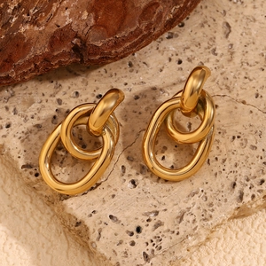 Détail de boucles d'oreilles géométriques torsadées en forme d'O plaquées or 18 carats